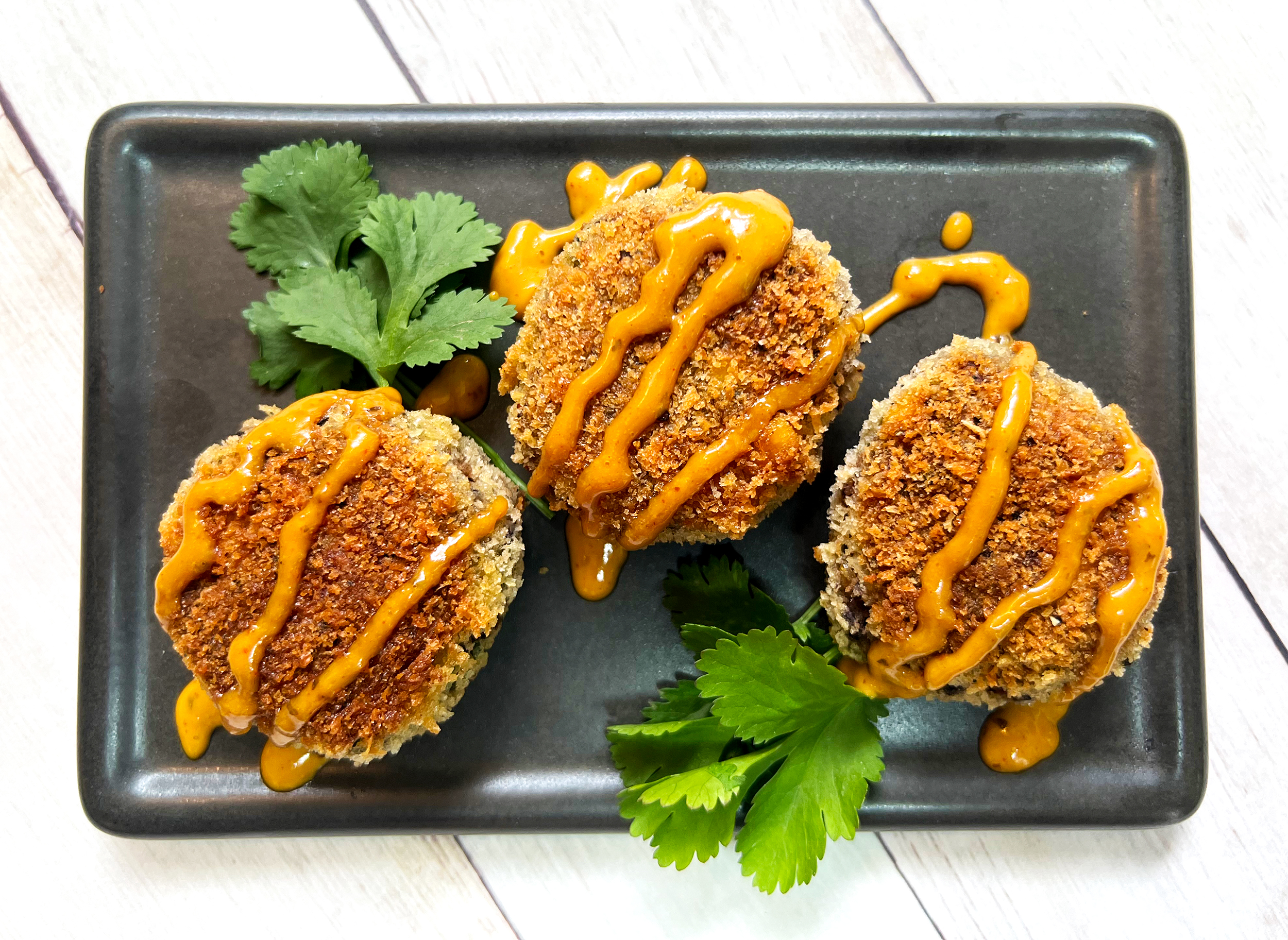 SPICY BLACK BEAN CAKES TOPPED WITH YUMM SAUCE 